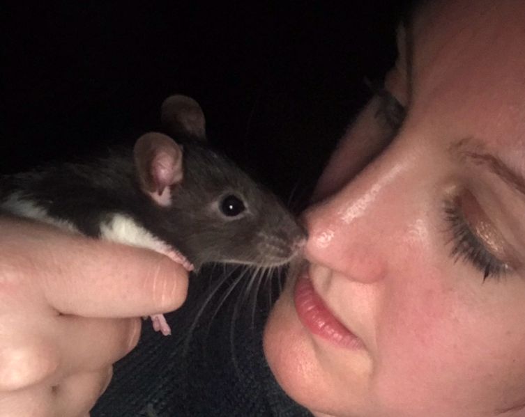 Pixie Greatorex, freelance pet blog writer holding a black and white rat to her nose