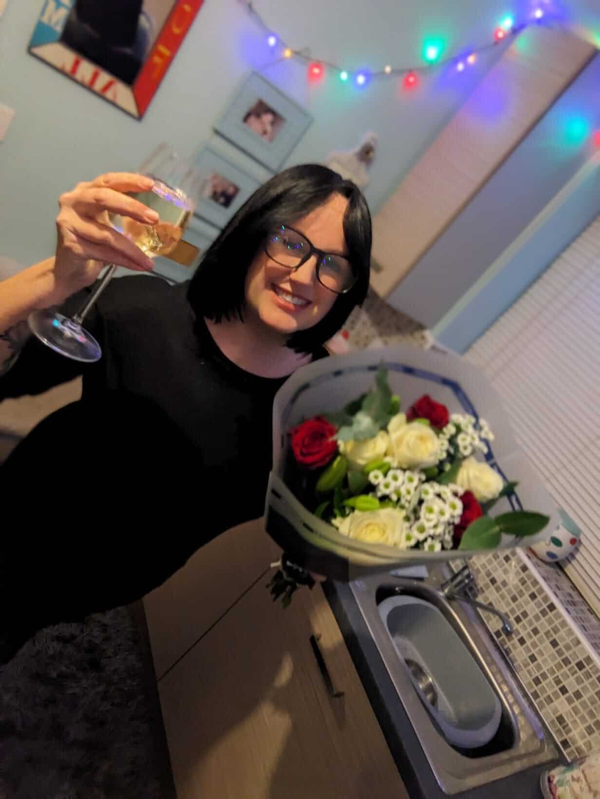 Pixie Greatorex Pet Industry Writer with flowers and a glass of wine